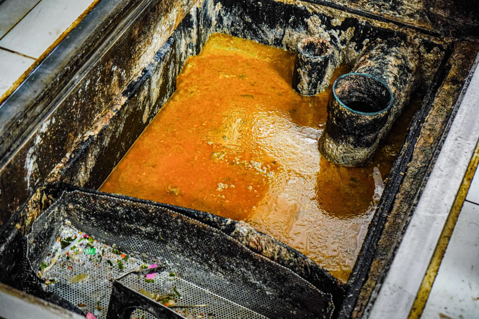 Grease Trap Cleaning Hazelcrest IL – open interceptor with a thick orange FOG cap waiting to be pumped in Hazel Crest